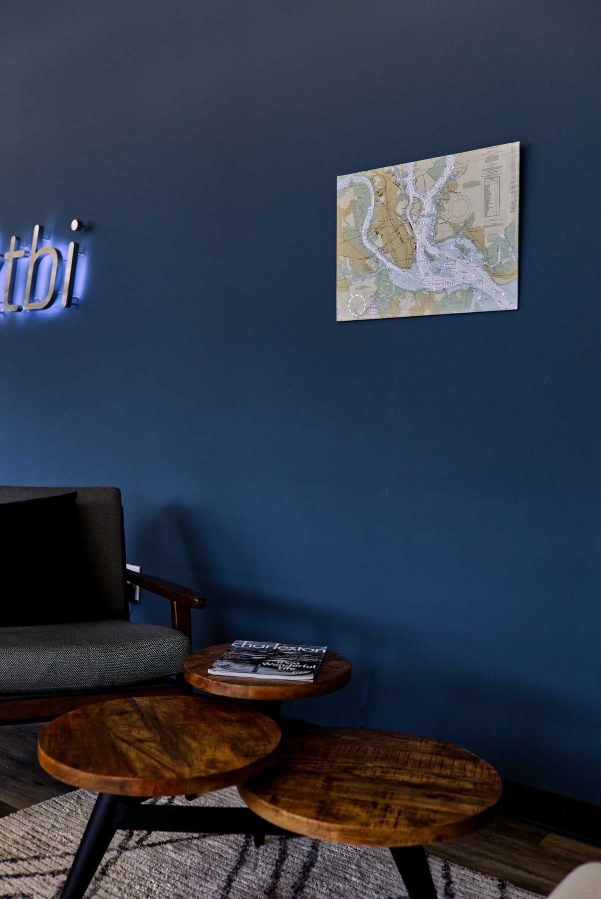 Image of the LightMap Sea showing the Charleston harbor and illuminated with live wind, weather, tide, buoys, and lighthouses. Mounted on a blue background in a lobby.